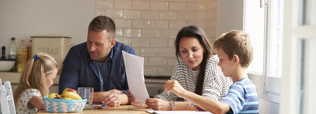 Gezin aan keukentafel met huiswerk