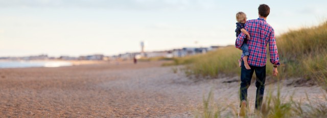 Man met kind bij zee